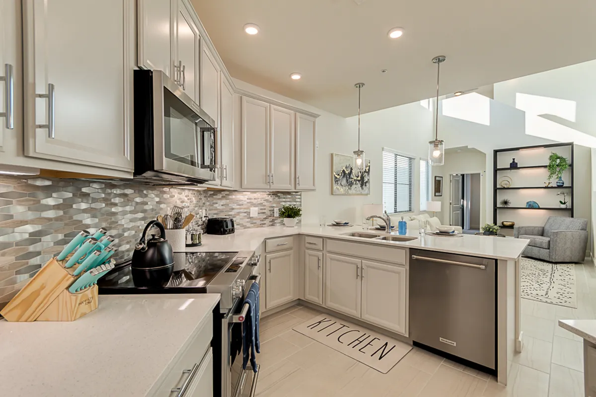 A modern kitchen with sleek cabinets, a stylish backsplash, a central island for gathering, and a comfortable seating area. The space encourages casual dining, meal prep, and impromptu gatherings, reinforcing the idea of a home base for extended business stays.