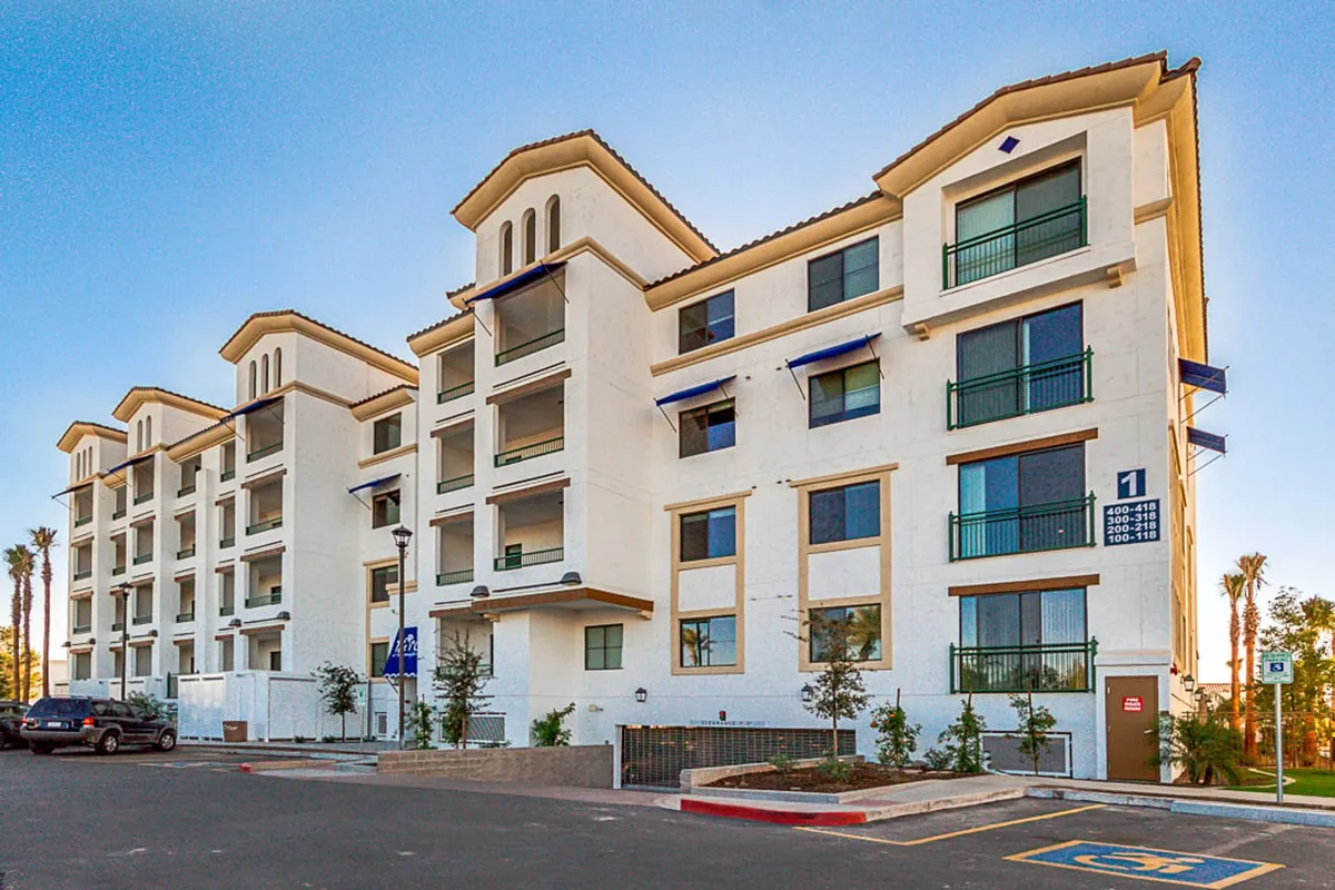 This exterior image captures modern architecture, inviting balconies, and manicured landscaping, hinting at communal outdoor spaces. The scene suggests opportunities for outdoor relaxation, community gatherings, and active family life, which aligns with the resort's amenity-rich lifestyle.